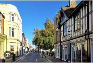 a person walking down a city street with buildings at Beautiful 3-Bed Apartment in Hythe High Street in Hythe