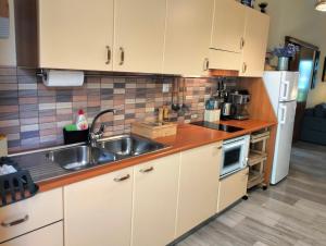 a kitchen with white cabinets and a sink at Helens Apartment in Tolo