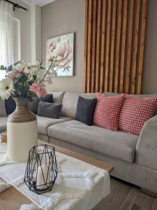 una sala de estar con sofá y un jarrón de flores en Pietra di Luna 1, en Kriopigi