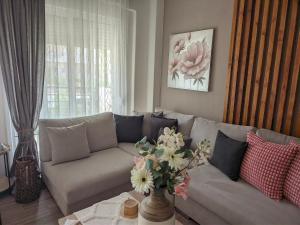 a living room with a couch with a vase of flowers at Pietra di Luna 1 in Kriopigi