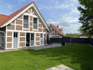 a brick house with a lawn in the yard at Meerglück CUX in Cuxhaven