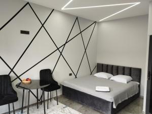 a bedroom with a bed and a table and chairs at Lumi in Bishkek