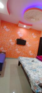una habitación con una pared naranja con nubes blancas. en HOTEL ATITHI GALAXY en Kānpur
