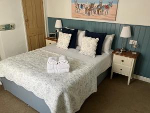 a bedroom with a bed with two towels on it at Seashell Cottage in Whitby