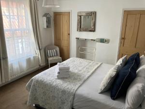 a bedroom with a bed with towels on it at Seashell Cottage in Whitby