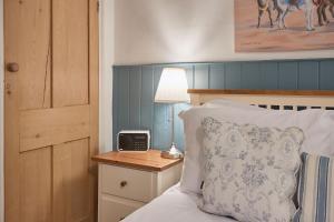 a bedroom with a bed with a clock on a night stand at Seashell Cottage in Whitby