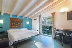 a bedroom with a bed and a table and a window at Marilena in Castelnuovo del Garda