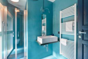Baño azul con lavabo y espejo en Marilena, en Castelnuovo del Garda