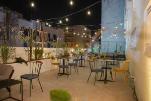 un patio con mesas, sillas y luces en Hotel Ibn Khaldoun en Túnez