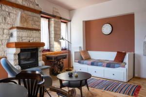 a living room with a couch and a fireplace at Βερβερίτσα in Monodendri