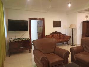 sala de estar con sofá y TV en Beach view luxury apartment, en Karagampitiya
