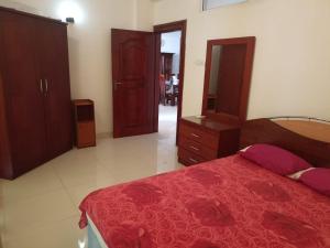 1 dormitorio con 1 cama con edredón rojo en Beach view luxury apartment, en Karagampitiya