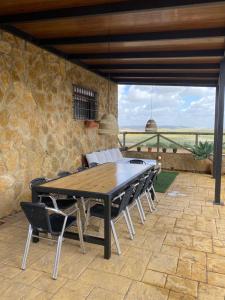 Une table et des chaises en bois sont disponibles sur la terrasse. dans l'établissement Casa Rural El Almendrillo, à Arcos de la Frontera