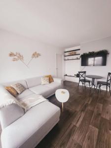 een witte woonkamer met een bank en een tafel bij Apartamento en Disneyland Paris in Chessy