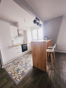 une cuisine avec des armoires blanches, une table et un tapis dans l'établissement Apartamento en Val d'erurope, à Chessy