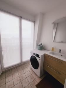 une salle de bain avec un lavabo et une machine à laver dans l'établissement Apartamento en Val d'erurope, à Chessy 32 autres photos