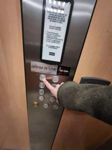 une personne appuie sur un bouton dans un ascenseur dans l'établissement Apartamento en Val d'erurope, à Chessy