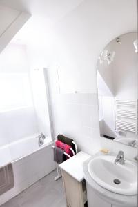Baño blanco con lavabo y espejo en Maison de 2 chambres avec jardin clos a Grevilly en Grevilly