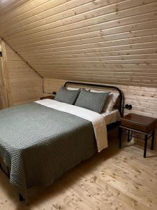 een slaapkamer met een bed en een houten muur bij Rest House in Oni