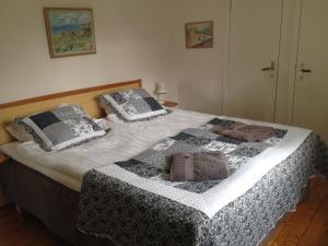 una camera da letto con un letto con una coperta e cuscini di Hermanslycke Bed & Breakfast a Tvååker