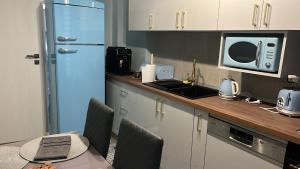 a kitchen with a blue refrigerator and a microwave at Live Tulcea Hotel in Tulcea
