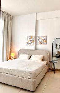a bedroom with a large bed with white sheets at Cozy Central Apt with Parking and Skyline View in Dubai