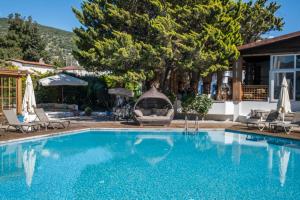 a swimming pool with chairs and a house at Costa Bodrum City in Bodrum City