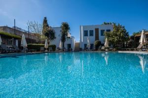 a large swimming pool with chairs and umbrellas at Costa Bodrum City in Bodrum City