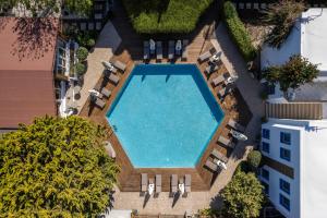 an overhead view of a swimming pool with chaises and chairs at Costa Bodrum City in Bodrum City