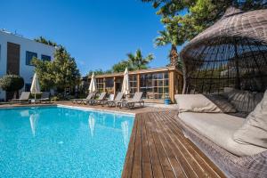 a swimming pool with a couch and chairs next to a building at Costa Bodrum City in Bodrum City