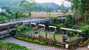 a train station with a garden next to a road at HillView Munnar in Munnar
