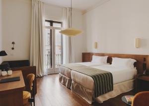 a hotel room with a large bed and a desk at Hotel Regina Barcelona in Barcelona