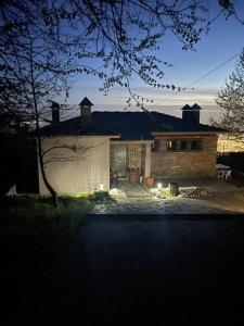 una casa iluminada por la noche con un garaje en Apple House, en Portaria