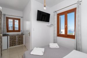 Una habitación blanca con una cama y una ventana. en Sunset studio in Plaka, en Plaka Milou