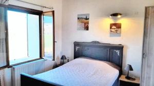 um quarto com uma cama e uma grande janela em Maison d'une chambre avec wifi a Sainte Jalle em Sainte-Jalle