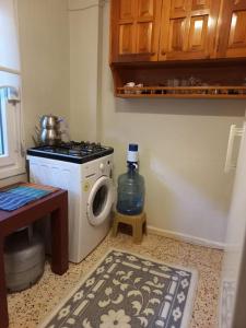 een wasruimte met een wasmachine en een fles water bij Plaja 100m, bahçe katı, 1+1 daire. in Ayvalık