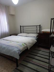 1 dormitorio con 2 camas individuales y alfombra en Plaja 100m, bahçe katı, 1+1 daire. en Ayvalık