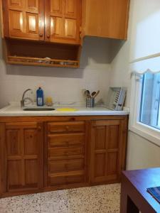 a kitchen with wooden cabinets and a sink at Plaja 100m, bahçe katı, 1+1 daire. in Ayvalık
