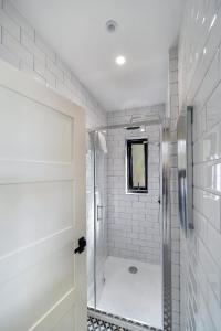 baño blanco con ducha y puerta de cristal en Seaview Lodge Studio 'Sleeping 2 guests' en Burnfoot