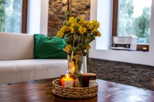 a vase with yellow flowers and a candle on a table at Traditional stone build country house Shale 
