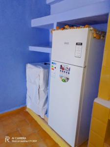 een witte koelkast in een kamer met een blauwe muur bij Dar Sakina in Chefchaouene