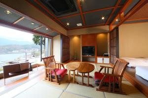 富士河口湖町にある時悠々楽游のベッド、テーブル、椅子が備わる客室です。