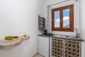 una cocina con fregadero y ventana en Sunset studio in Plaka, en Plaka Milou