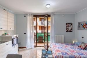 El Sol Residence - Modern house near Milan في Dresano: مطبخ وغرفة نوم مع سرير في غرفة