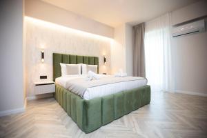 - une chambre avec un grand lit et une tête de lit verte dans l'établissement 18th Elite View by Tower Apartments, à Cluj-Napoca