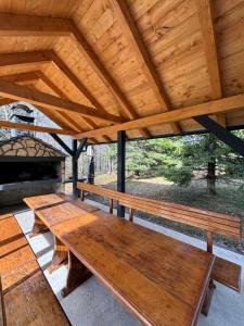 un groupe de bancs en bois assis sous un toit dans l'établissement Chalet Mint, à Delnice