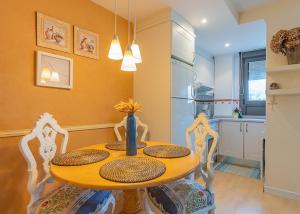 a dining room table with four chairs and a kitchen at Apartamento Sueve 24 in Colunga