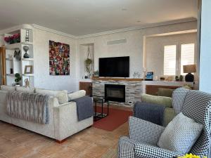 ein Wohnzimmer mit 2 Sofas und einem TV in der Unterkunft La Encina, casa tranquila con excelentes vistas in Mesones