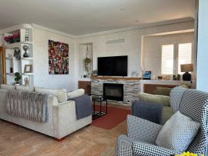 a living room with two couches and a television at La Encina, casa tranquila con excelentes vistas in Mesones