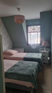 1 Schlafzimmer mit 2 Betten und einem Fenster in der Unterkunft Appartement Clos Mathilde in Cabourg
